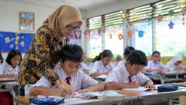 Ilustrasi orang tua melakukan pendaftaran Pra SPMB SD Kota Tangerang 2026 secara online melalui perangkat komputer.