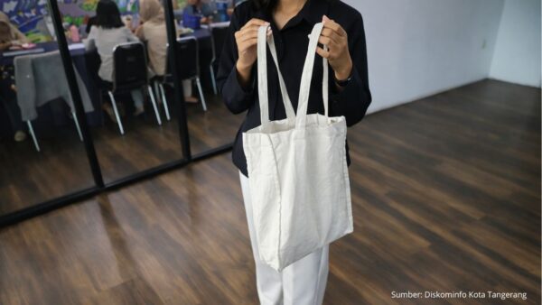 Warga menggunakan tas belanja ramah lingkungan saat berbelanja di pasar.